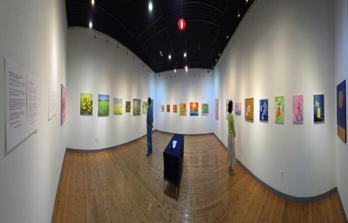 광양역사문화관 전시실에 서양화가 허랑 문경애 ‘결의 시간, 빛의 도약-생명의 연대기’란 주제의 작품들과 작품을 관람객이 감상하고 있다.